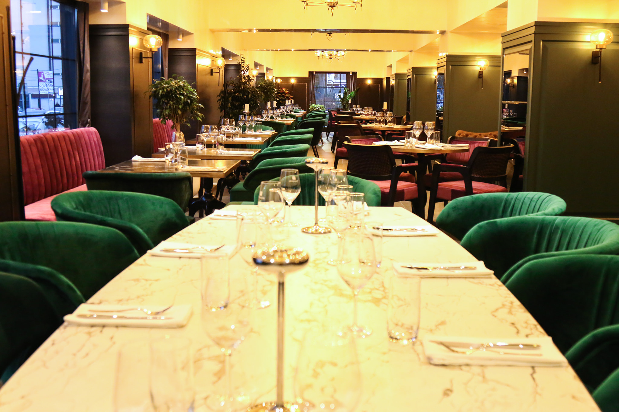 Dining area with green upholstered seating at COTTO